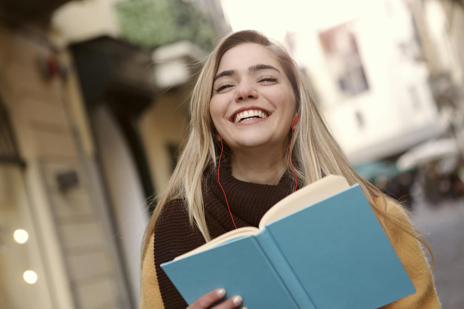 Chica rubia camina por la calle contenta tras realizar examen de selectividad