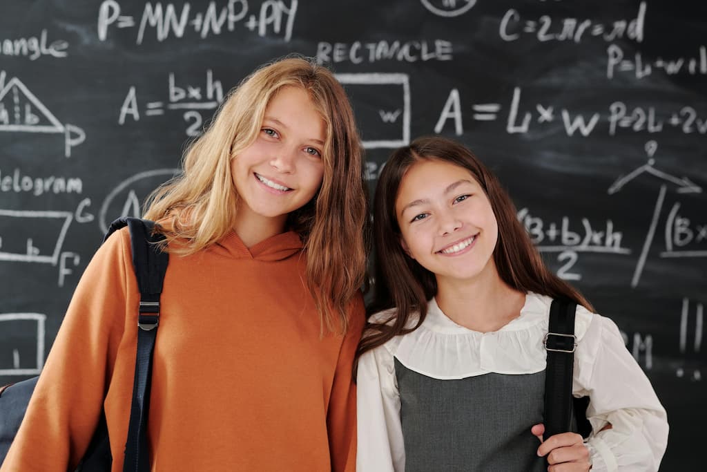 Dos jóvenes estudiantes sonríen en clase